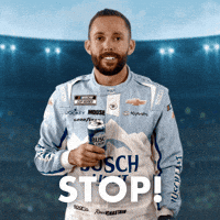 Sponsored gif. NASCAR driver Ross Chastain motions to stop with his left hand while holding a can of Busch Light beer in his right hand. He wears a driver fire suit decorated with many sponsor logos with the largest being the Busch Light beer logo across the center of his abdomen. Text reads, “Stop!”
