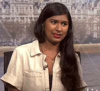 Video gif. Confused woman sits deep in thought, having an internal debate before coming to a sudden realization.