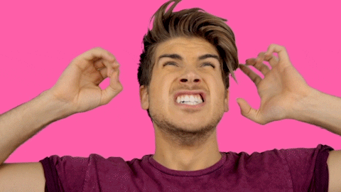 Celebrity gif. Joey Graceffa raises his hands by his head as he screams angrily.