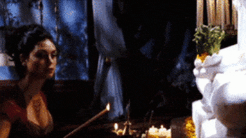 TV gif. Morena Baccarin as Inara on Firefly lights an incense stick next to what appears to be an altar.