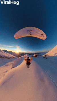 Paraglider Flies Over Golden Hour Mountains