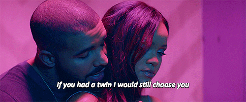 Music video gif. From the video for Work, Drake whispers into Rihanna's ear from behind as they dance beneath blue and pink lighting, singing, "If you had a twin I would still choose you," which appears as text.