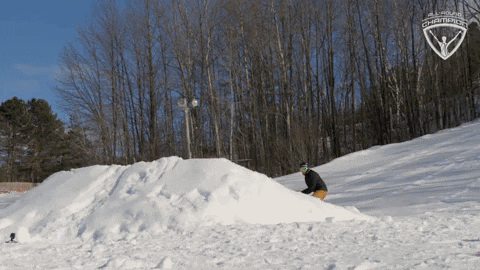 Sports gif. Snowboarder jumps off a ramp, expertly grabbing his board behind him as he flies through the air.