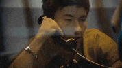 Music video gif from Sabrina Carpenter's music video for "Please Please Please." Barry Keoghan talks into a telephone receiver, behind a glass partition in jail.
