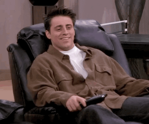 Friends gif. Sitting in a black recliner, Matt LeBlanc as Joey laughs at something on the television, then turns to see what Chandler thinks before realizing in deep disappointment the recliner next to him is empty.