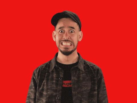 Video gif. We zoom in and out on a nervous-looking Mike Shinoda. Each time we zoom in, the solid red background becomes a pink and gray spiral.
