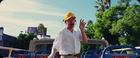 News MEI - Edição 17 - gif de homem, com boné amarelo e de bigode, apontando para as ruas em cima de um ônibus aberto de turismo.