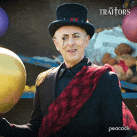 Sponsored gif. Alan Cumming as host of The Traitors in a top hat, black suit, and red sash looks confused and tilts his head to the side in thought. Text reads, “Doesn’t sound good.”