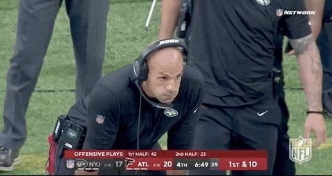 Sports gif. Robert Saleh, head coach of the New York Jets, is leaning forward with his hands on his thighs and he blows air out of his mouth before hanging his head.
