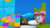 Cartoon gif. From Storybots, a sleeping teddy bear being woken up by a pink alarm clock, uses a jumbo robot arm to slap the snooze button.