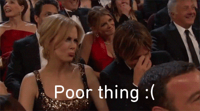 Celebrity gif. Nicole Kidman and Keith Urban sit next to each other in the audience of a reward show. Nicole Kidman looks up at the stage and pouts, saying, “Poor Thing.” Keith Urban looks down, pinching the bridge of his nose, and shaking his head.