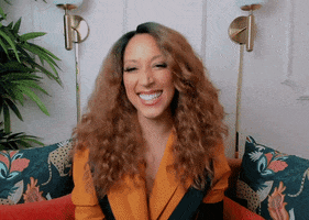 Celebrity gif. Robin Thede smiles happily and claps her hands in gratitude.