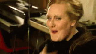 Celebrity gif. Adele teasingly points at us before breaking out into a contagious laughter.