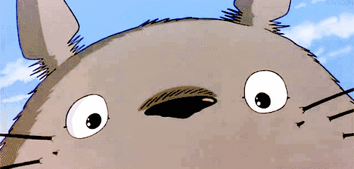 Anime gif. Close-up of the face of Totoro, giving a big toothy grin, from My Neighbor Totoro.