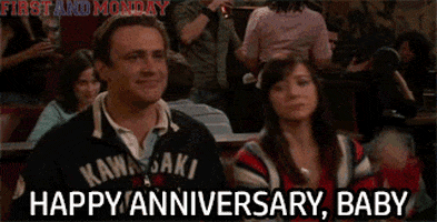 TV gif. Jason Segel as Marshall and Alyson Hannigan as Lily in How I Met Your Mother sit next to each other in a booth at a restaurant. He smiles and she looks serious as they high five. Text, "Happy Anniversary, Baby"