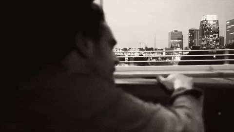 Animated GIF of the Joker sitting in a car with playful and chaotic movements