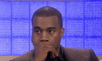 TV gif. Kanye West listens to something offscreen with minimal reaction, holding a hand over his mouth and blinking.
