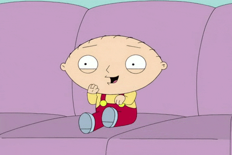 Cartoon gif. Stewie from Family Guy sits on a couch and excitedly shakes his hands and legs. 