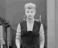 TV gif. Lucille Ball as Lucy puts her arms out to the side in an exaggerated shrug as she raises her eyebrows with a frown like, 