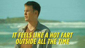 Movie gif. Zach Cregger as Owen in Wrecked stands on a beach and speaks emphatically, saying, It feels like a hot fart outside all the time.
