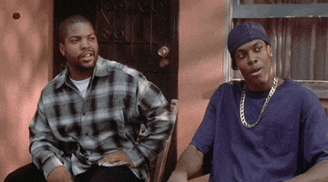 Movie gif. Ice Cube as Craig Jones and Chris Tucker as Smokey in Friday sit outside on a porch. They jump in their seats and lean back out of fear while saying, “Damn!”