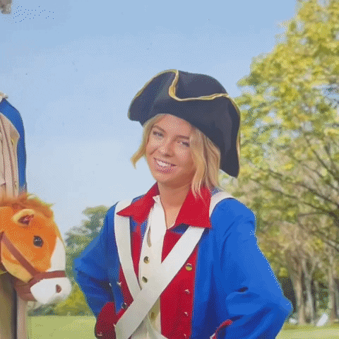 Video gif. Blonde girl is dressed up as a pirate, but it doesn't appear to be out of her own will. As we zoom in closer, she stands and smiles awkwardly, but her eyes show her discomfort.