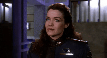 TV gif. Claudia Christian as Susan Ivanova in "Babylon 5" nods her head quickly, then smiles and takes a sip of orange juice from a glass, saying, "Thank you!'