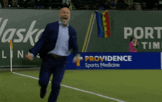 Sports gif. Giovanni Savarese, the head coach of the Portland Timbers, is ecstatic. He runs on the field and does a big jump, thrusting his arm in an air punch. He can't contain his excitement as he yelps.