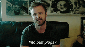 Celebrity gif. Aaron Paul looks at us as he nods his head assertively and says, "Into butt plugs?"