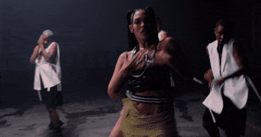Music video gif. From Dizzy Fae's Bend and Snap video, the rapper and her dancers spin around with their backs to us, bend over then slowly ease back up.