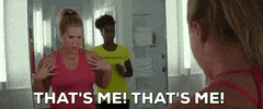 Movie gif. Amy Schumer as Renee in I Feel Pretty, looking at her self in the mirror in disbelief and pointing at herself while saying, "that's me! That's me!" which appears as text. Sasheer Zamata as Tasha stands behind her, nodding and smiling.