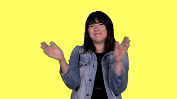 Celebrity gif. Emily Warren shakes her head, clapping against a bright yellow background.