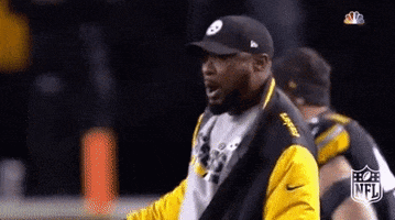 Sports gif. Mike Tomlin, coach of the Pittsburgh Steelers, rallies his team as they rush out onto the field ahead of him. He revs his arm back and whoops them on as they run.