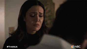 TV gif. Mandy Moore as Rebecca on This Is Us, looking sad as she wraps her arms around Milo Ventimiglia as Jack, who then blinks hard, like he's crying.