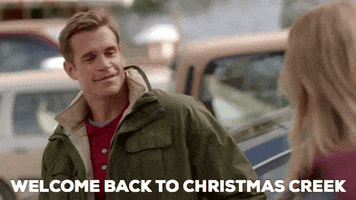 Movie gif. Stephen Huszar as Mike in Return to Christmas Creek smiles kindly at Tori Anderson as Amelia and says "Welcome back to Christmas Creek," which appears as text.
