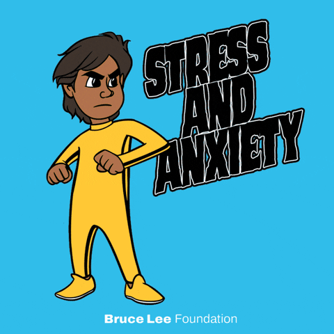 Digital art gif. Cartoon image of Bruce Lee wearing a yellow jumpsuit kicks the text, "Stress and anxiety," which explodes to reveal the text, "Serenity and strength," all against a bright blue background. Text, "Bruce Lee Foundation."