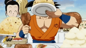 Anime gif. Goku from Dragon Ball sits at a table covered in different foods. He holds a plate of fried rice up to his face and eats. In his other hand is a drumstick. A woman stands next to him with a huge pile of fried rice on a plate.