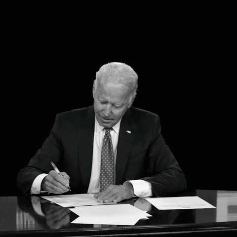 Photo gif. Black and white photo of President Biden signing a bull at a desk against a black background. Text, “The Inflation Reduction Act will tackle inflation, lower costs, and reduce the deficit.”