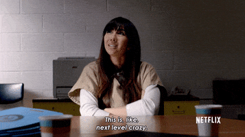 TV gif. Jackie Cruz as Marisol Gonzales in Orange Is the New Black sits at a desk and says, "This is, like, next level crazy," punctuating her statement with an okay sign with her hand.